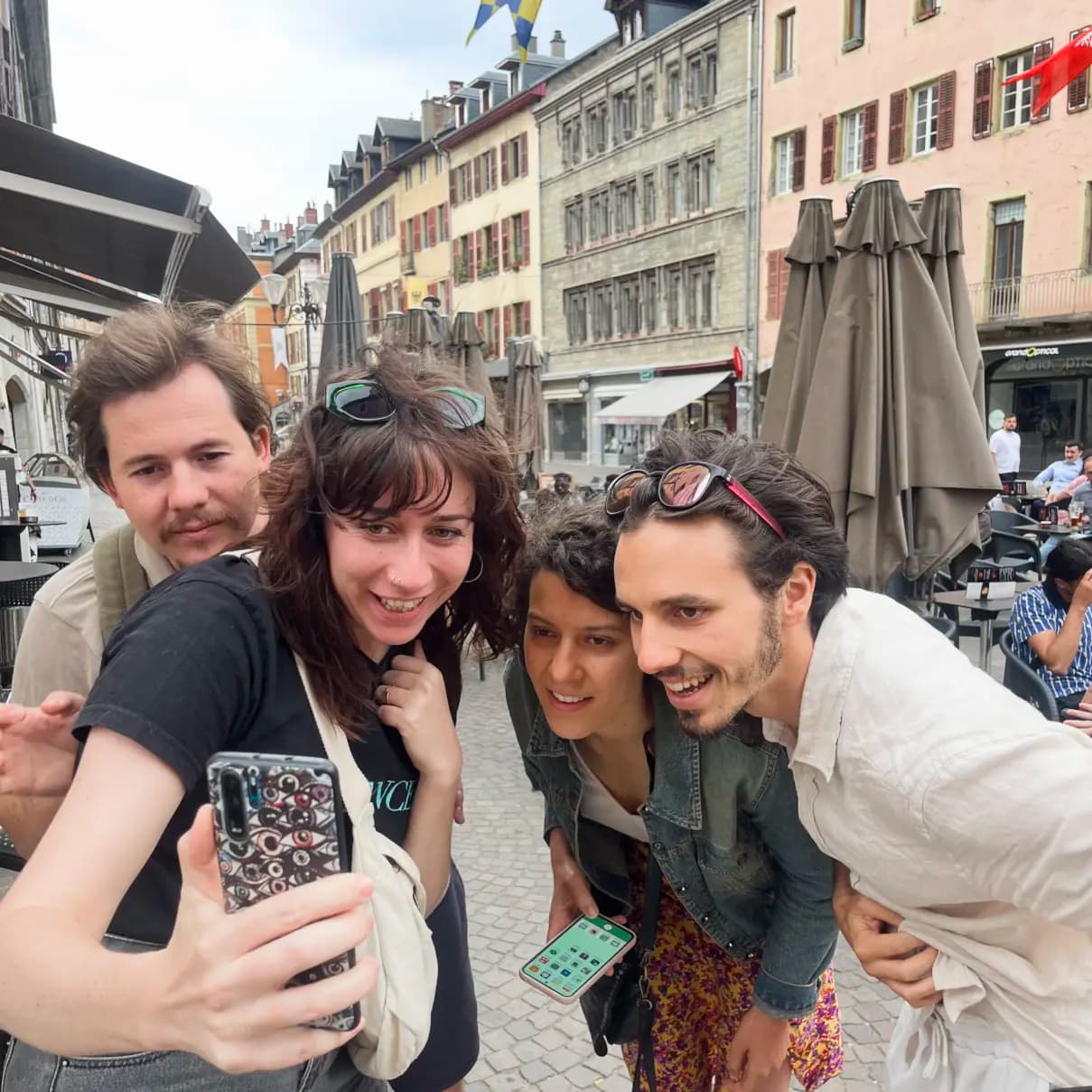 Personnes souriantes regardant un téléphone